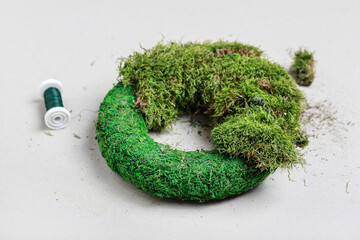 Florist at work: woman shows how to make classic moss wreath. Step by step, tutorial.
