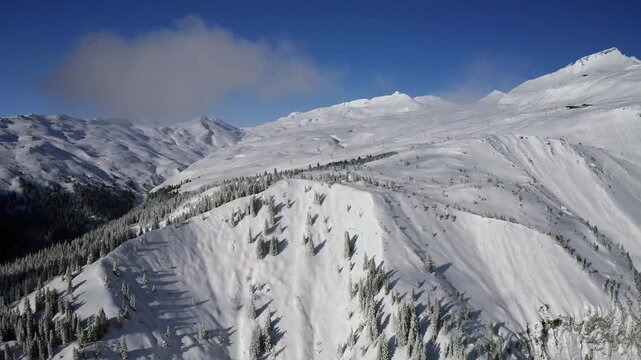 Aerial winter view of Naraus with snow covered alpine landscape and clear blue sky