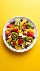 Vibrant and Colorful Fresh Fruit Salad on a Bright Yellow Background.