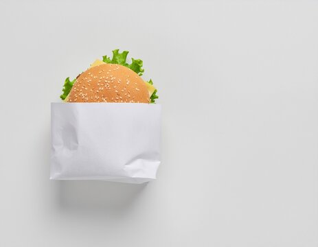 Delicious burger peeking out from a white paper bag
