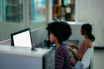 Students concentrating on computer screens inside library reflecting research activity focused study routine higher education environment.