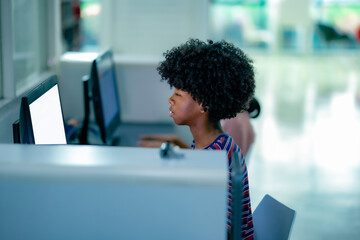Students seated at library computer desks engaging in online research representing modern study habit academic focus learning environment.