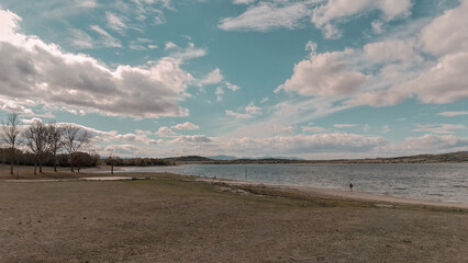 Wide lakeside landscape with shoreline and dramatic cloudscape in Spain
