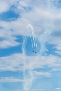 Aerobatic Airplanes Performing Smoke Trails in Blue Sky