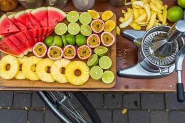 Fresh fruit slices on wooden cutting board with juicer