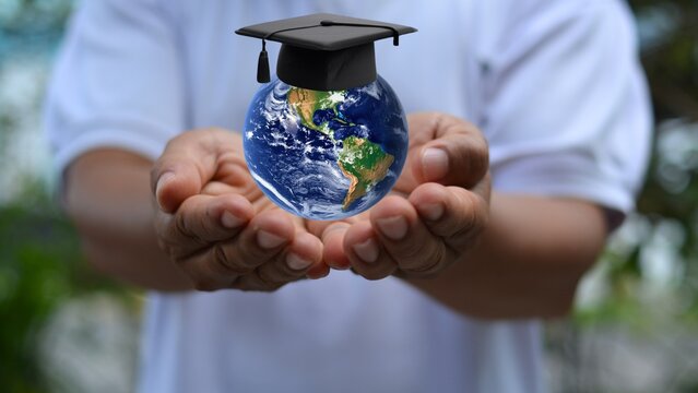 Earth wearing a graduation cap on a man's hand. International day of education - Powered by Adobe