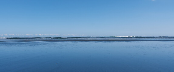 Fototapeta premium Minimalist coastal landscape with blue sea and distant clouds