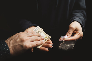 Close-up of addicted person hands paying cash to buy two transparent bags with narcotics, white...