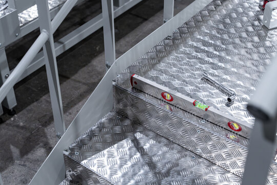 Escalier en m&eacute;tal dans un atelier industriel, illustrant une structure fonctionnelle et robuste utilis&eacute;e pour l&rsquo;acc&egrave;s aux diff&eacute;rentes zones de travail en environnement professionnel.