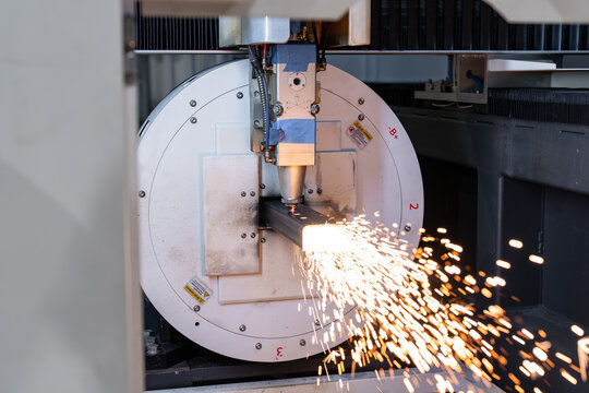 Machine industrielle d&rsquo;usinage de pr&eacute;cision en atelier, avec une grande pi&egrave;ce circulaire blanche et une t&ecirc;te de fraisage positionn&eacute;e au-dessus d&rsquo;un bloc m&eacute;tallique, illustrant un processus de fabricat