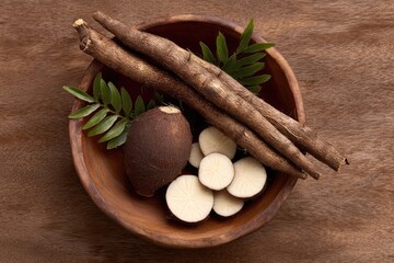 Wooden bowl holding roots and sliced tuber