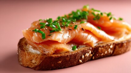 A delectable slice of toasted bread topped with succulent smoked salmon and vibrant green chives, embodying a luxurious yet simple dish that invites taste and aesthetic enjoyment.