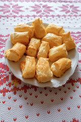Macro shot of fresh cheese puff pastry buns on a rustic wooden board