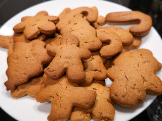 A plate full of warm gingerbread men cookies with cracked surfaces and golden brown edges, ready for festive gatherings. Perfect for Christmas, family baking, party snacks, and cozy holiday memories.