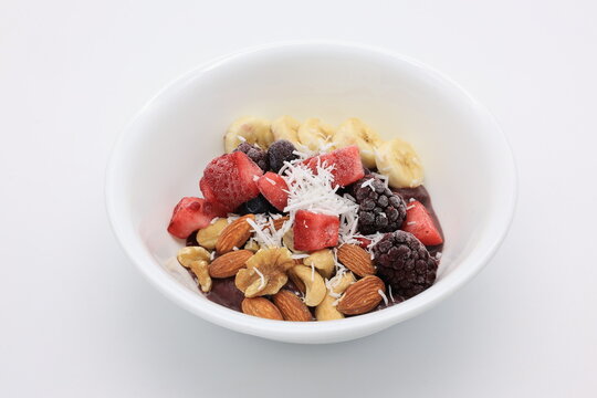 白い皿にドライフルーツやナッツが乗ったアサイーボウル