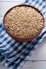 Oat Groats in Brown Bowl on Wooden Table Close-Up