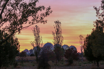 Spherical LPG fuel tanks in white and red colors at a facility near the city of Madrid
