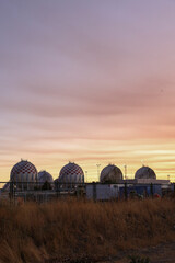 Spherical LPG fuel tanks in white and red colors at a facility near the city of Madrid