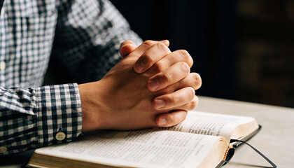 Hands on the Holy Bible. Prayer. Open Bible close-up. Religion concept.
