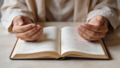 Hands on the Holy Bible. Prayer. Open Bible close-up. Religion concept.