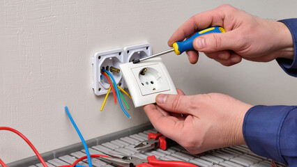 electrician fixing electrical outlet