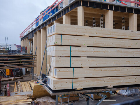 Modern timber construction site with stacked wooden beams and structural framework