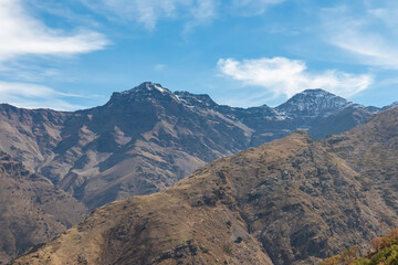 Breathtaking panoramic scenery of La Alcazaba and Pico del Mulhacen towering over the rugged valley, captured from the Vereda de la Estrella trail in the heart of Sierra Nevada, Andalusia, Spain.