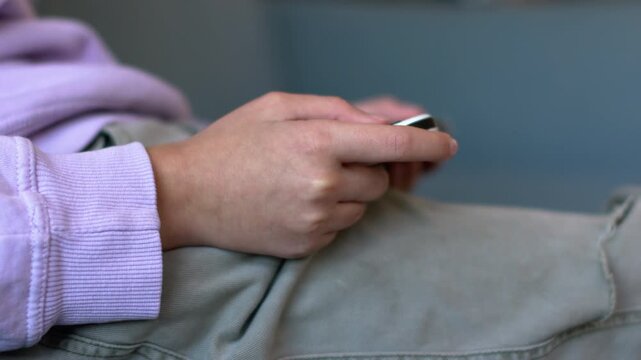 Child's hands holding a wireless game controller while playing a video game. Close-up. Gaming lifestyle and after-school entertainment. Child playing a video game.