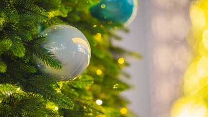 Christmas tree with white and blue ornaments and warm festive lights