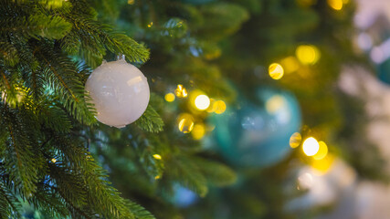 Christmas tree with white and blue ornaments and warm festive lights
