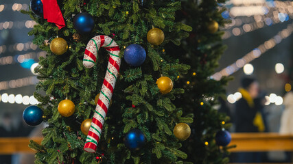 Christmas candy cane ornament on decorated Christmas tree