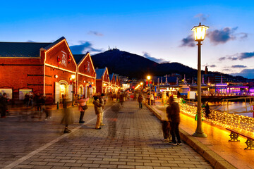 Cityscape of the historic red brick warehouses and Mount Hakodate at twilight on a winter evening in Hakodate, Hokkaido Japan 