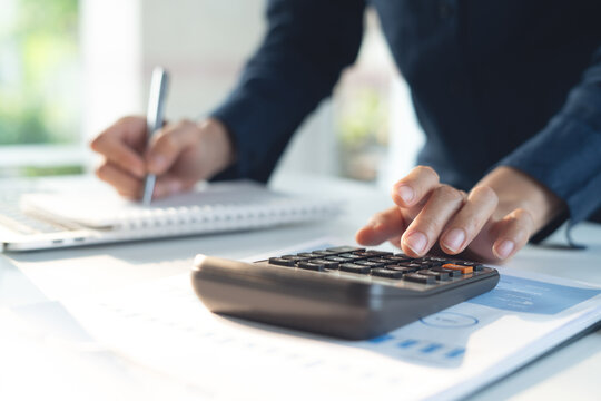 Business finance accounting banking concept. Businesswoman doing finances, using calculator to calculate business report on desk at office, budget planning, tax calculation