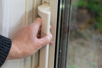 ガラス戸の取っ手を握る