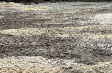 Fototapeta premium Workers are clearing muddy ground after recent rain at a construction site