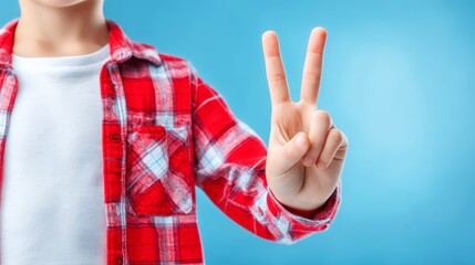 Young boy in red shirt makes peace sign child with red top displays peace gesture for camera