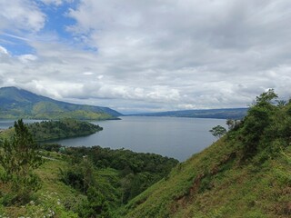Obraz premium Breathtaking view of Lake Toba from the lush green highlands of North Sumatra, Indonesia.