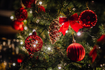 Festive Christmas tree adorned with vibrant red ornaments, sparkling lights, and decorative bows, creating a warm and joyful holiday atmosphere for celebration and gatherings