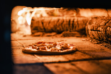 Traditional pizza cooking in wood fired oven