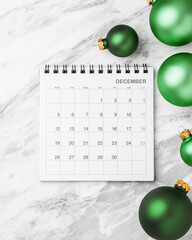 Calendar December with green christmas ball decoration on marble table background
