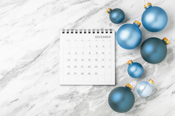 December calendar with blue christmas ball decoration on marble table background