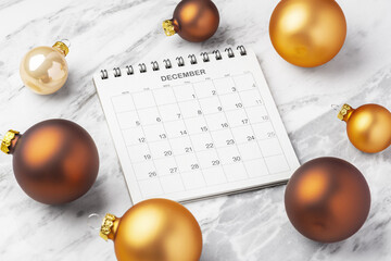 Calendar December with gold christmas ball decoration on marble table background