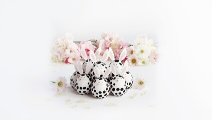 Humorous Easter display featuring black and white spotted eggs shaped like bunnies on a white backdrop, holiday decoration