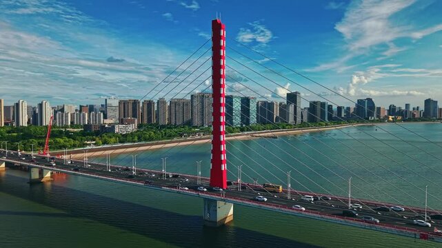 Aerial daytime view of cars and buses crossing Qiantang River Bridge in Hangzhou, China with city skyline.