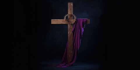 Cross with crown of thorns and purple cloth, used in Christian rituals, on dark background