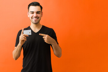 Cheerful man presenting a credit card, pointing to his chest. Financial services and new payment method concept