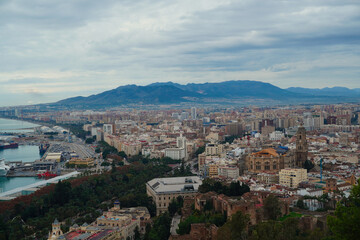 Fototapeta premium Panoramic view of Málaga showing the historic center, the cathedral and the port with the mountains in the background, highlighting the urban landscape and cultural heritage of this coastal city