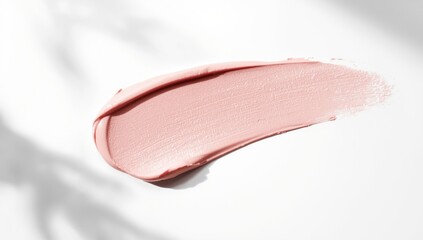 Fototapeta premium Swatch of pastel pink makeup on a plain white surface, designed for beauty product displays