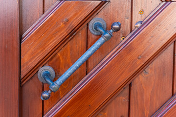 Beautiful wooden door with a sturdy handle in warm tones, highlighting craftsmanship and charm