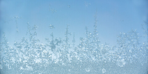 Close up photo of ice crystals on a frosty window pane surface, icy pattern, cold winter abstract background